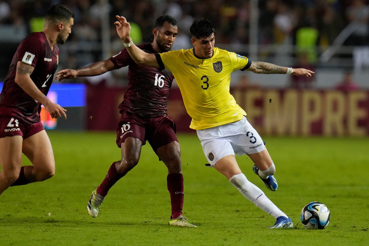 Piero Hincapié, de la selección de Ecuador, conduce el balón delante de Cristian Casseres, de Venezuela, en un encuentro de la eliminatoria mundialista, disputado el jueves 16 de noviembre de 2023 (AP Foto/Ariana Cubillos)