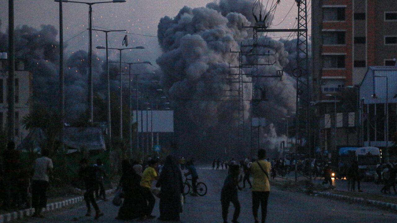 Los palestinos observan el humo que se eleva tras un ataque aéreo israelí en Deir al-Balah, en el centro de la Franja de Gaza,