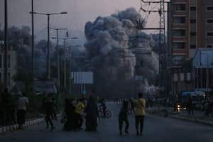 Los palestinos observan el humo que se eleva tras un ataque aéreo israelí en Deir al-Balah, en el centro de la Franja de Gaza.