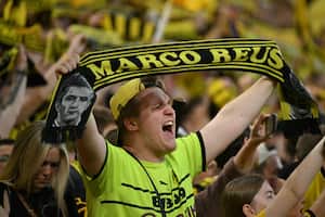 A Dortmund fan displaya a Marco Reus scarf as they sing "You'll Never Walk Alone" prior to the UEFA Champions League semi-final first leg football match between Borussia Dortmund and Paris Saint-Germain (PSG) on May 1, 2024 in Dortmund. (Photo by INA FASSBENDER / AFP)