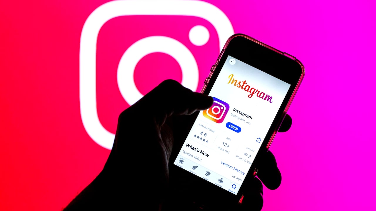 En esta ilustración fotográfica, la aplicación de Instagram en la App Store mostrada en la pantalla de un teléfono inteligente y un logotipo de Instagram en el fondo.