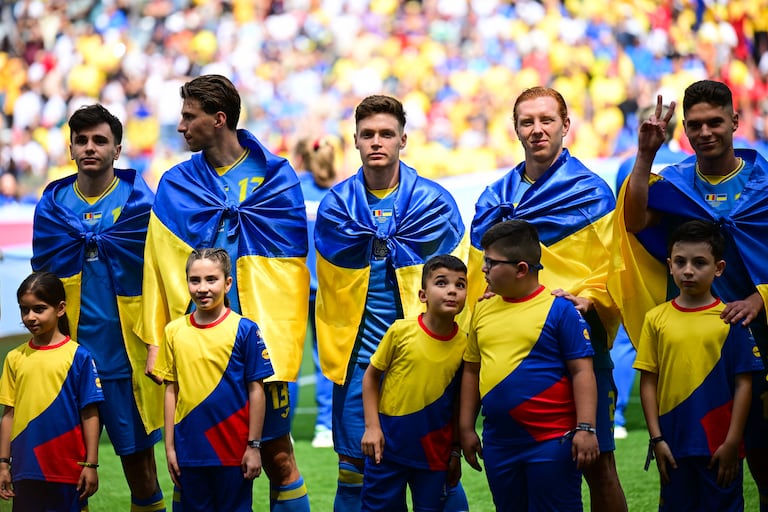 Jugadores entonan el himno de Ucrania previo al duelo frente a Rumania