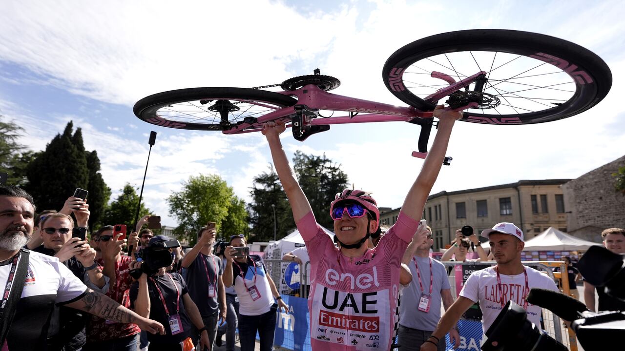 El esloveno Tadej Pogacar, vestido con la camiseta rosa del líder general de la carrera, sostiene su bicicleta mientras celebra después de ganar la vigésima etapa de la carrera ciclista Giro de Italia desde Alpago hasta Bassano del Grappa, Italia, el sábado 25 de mayo de 2024. (Fabio Ferrari/LaPresse vía AP)