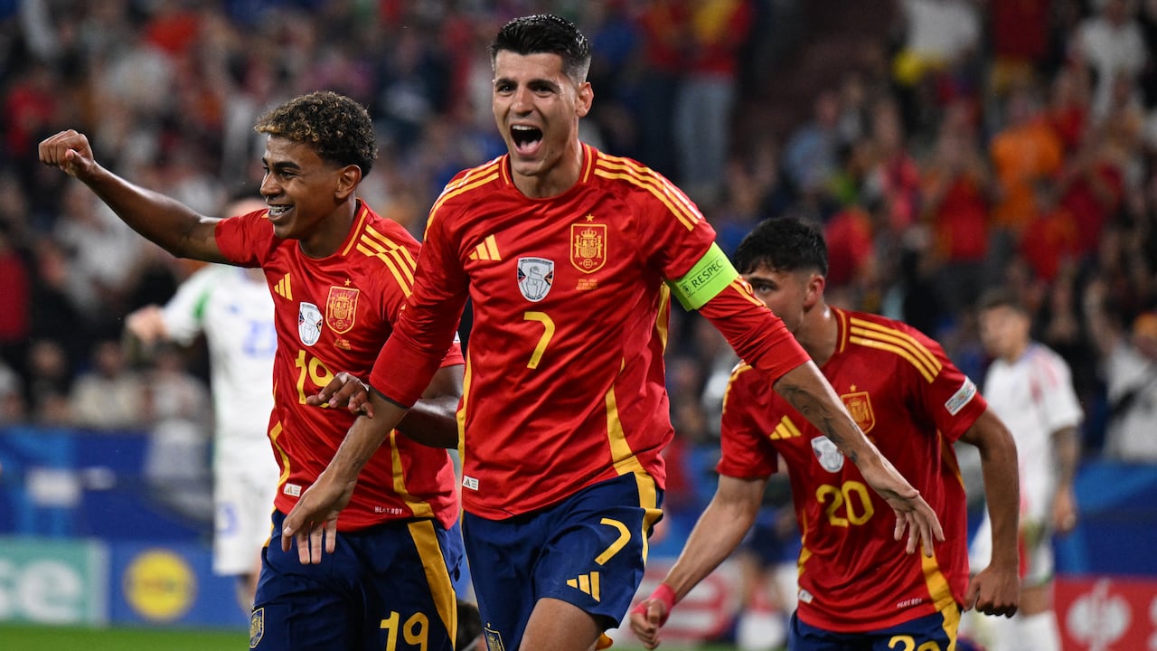 El delantero español #19 Lamine Yamal  y el delantero español #07 Alvaro Morata celebran después de que el defensor italiano #05 Riccardo Calafiori anota un gol en propia meta.