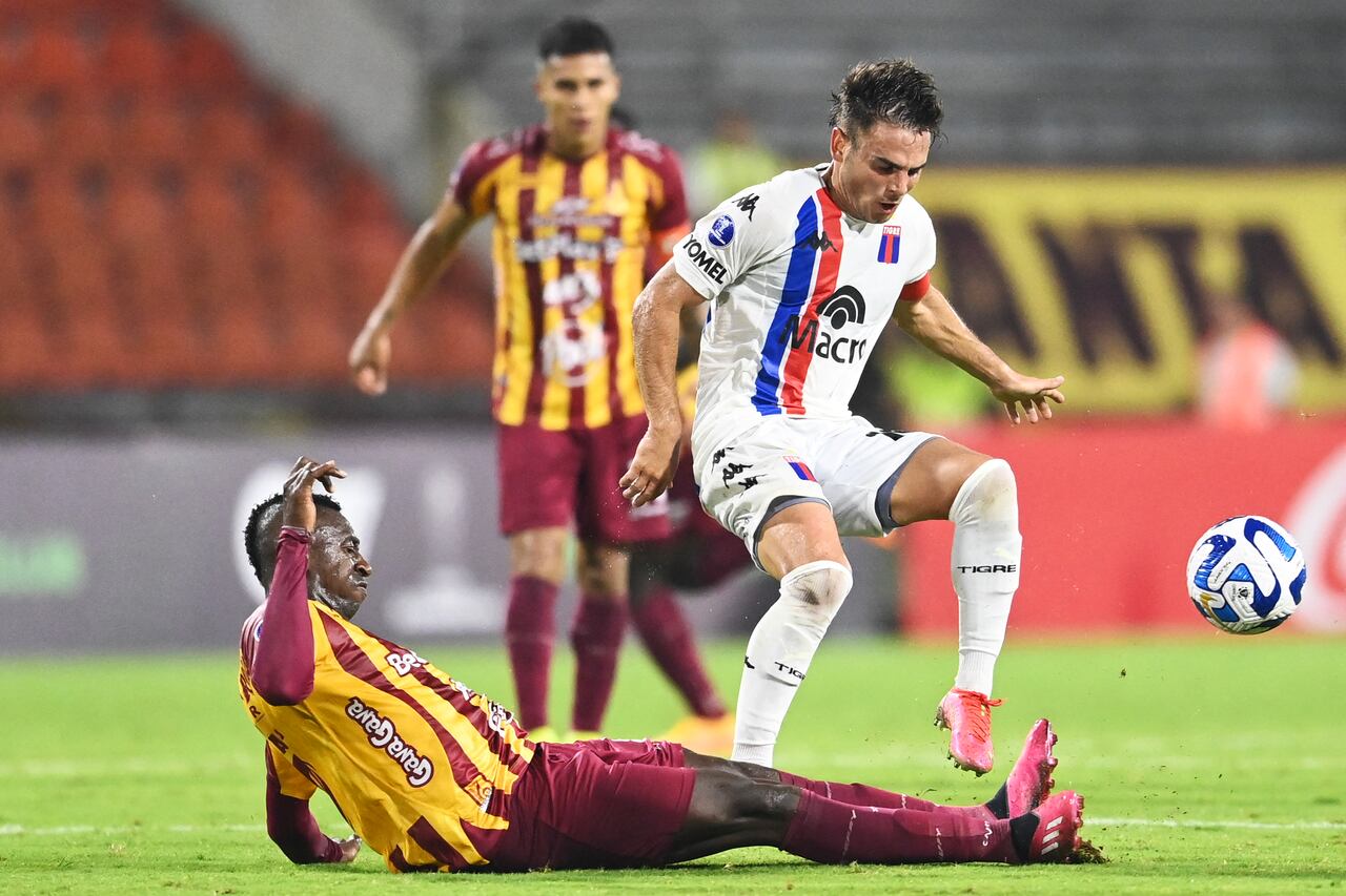 El mediocampista de Tigre Lucas Menossi (D) y el delantero del Tolima Juan Caicedo disputan el balón durante un partido de la Copa Suramericana.