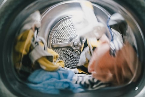A washing or a drying machine operating, domestic routine and chores concepts. Cleaning with ecological and environmental-friendly detergents and conditioners.