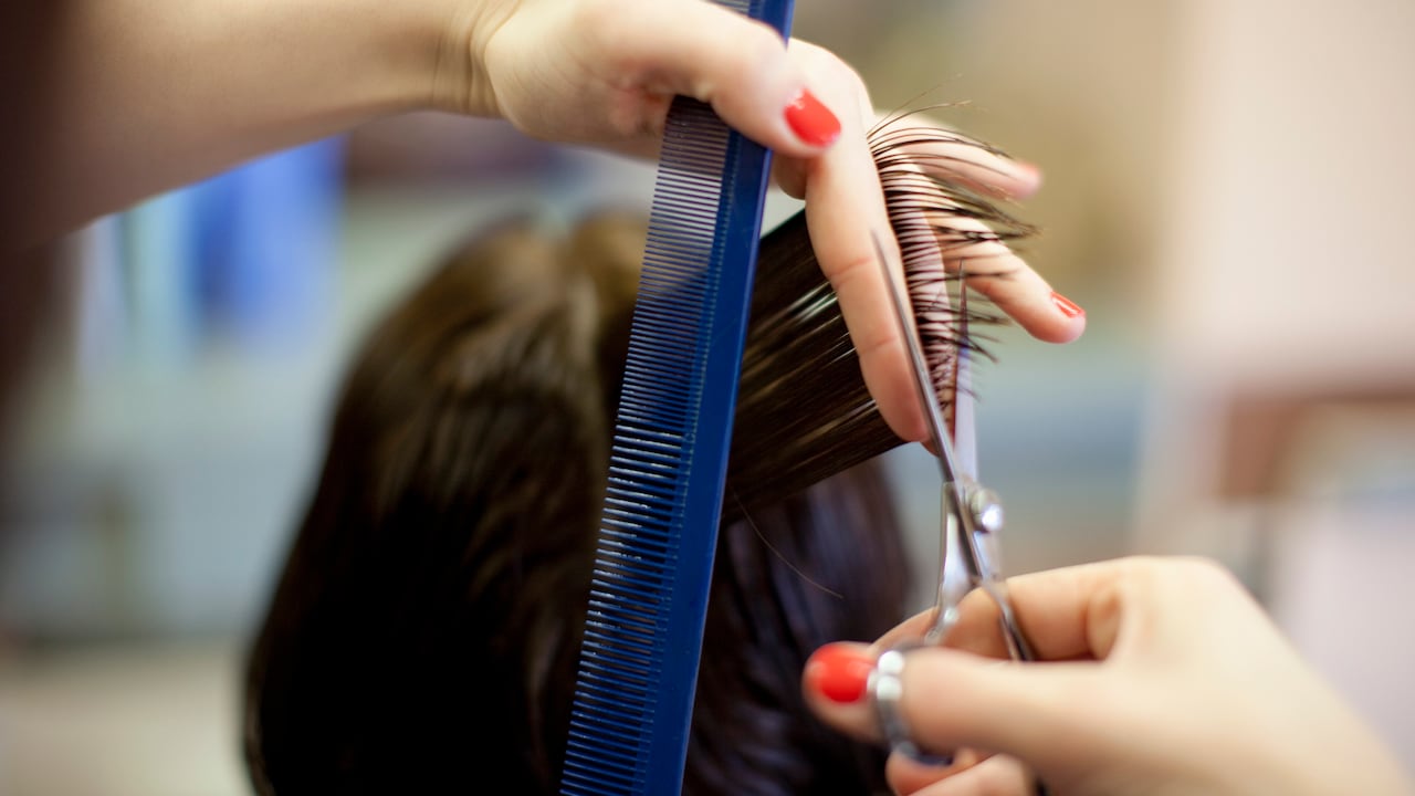 Woman 40s getting hair cut at hairdresser