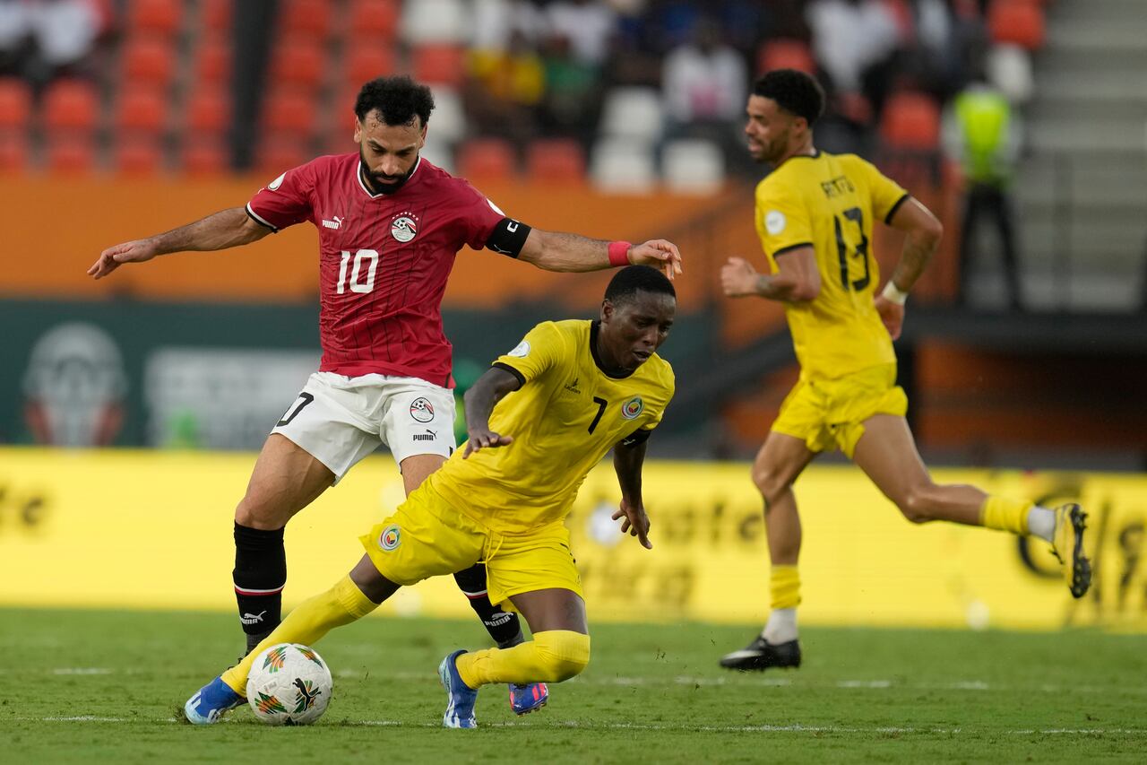 El mozambiqueño Elias Pelembe, a la derecha del egipcio Mohamed Salah durante el partido de fútbol del Grupo B de la Copa Africana de Naciones entre Egipto y Mozambique en Abiyán, Costa de Marfil, el domingo 14 de enero de 2024. (AP Foto/Themba Hadebe)