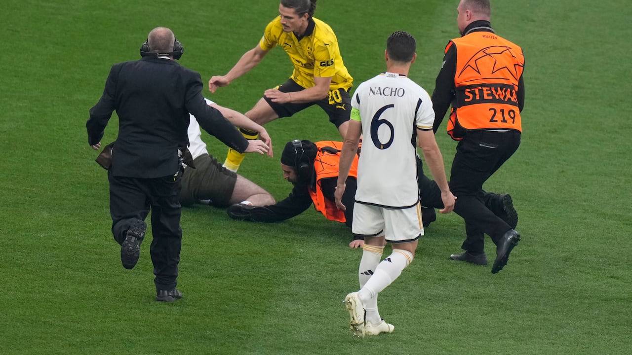 Dortmund's Marcel Sabitzer, second left, and stewards chase a pitch invader during the Champions League final soccer match between Borussia Dortmund and Real Madrid at Wembley stadium in London, Saturday, June 1, 2024. (AP Photo/Alastair Grant)