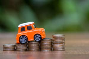 Carro y monedas sobre el precio que vale un seguro