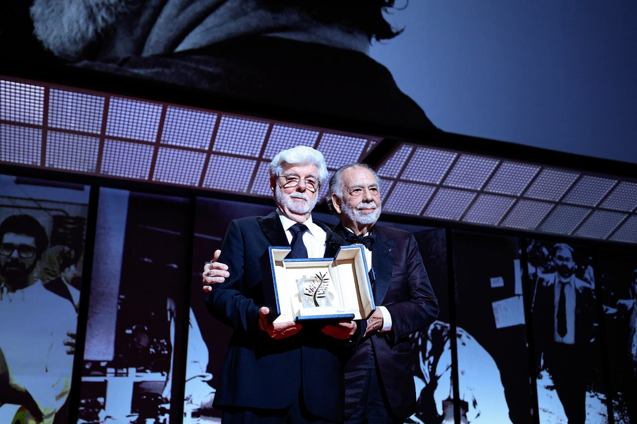 El director estadounidense George Lucas (izq.) pasa junto al director estadounidense Francis Ford Coppola después de recibir la Palma de Oro Honoraria durante la ceremonia de clausura de la 77.ª edición del Festival de Cine de Cannes en Cannes, sur de Francia, el 25 de mayo de 2024. (Foto de Valéry HACHE / AFP)