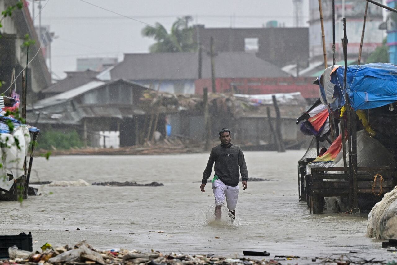 Un hombre camina por una carretera inundada durante la lluvia en Patuakhali el 27 de mayo de 2024, tras la llegada a tierra del ciclón Remal en Bangladesh.