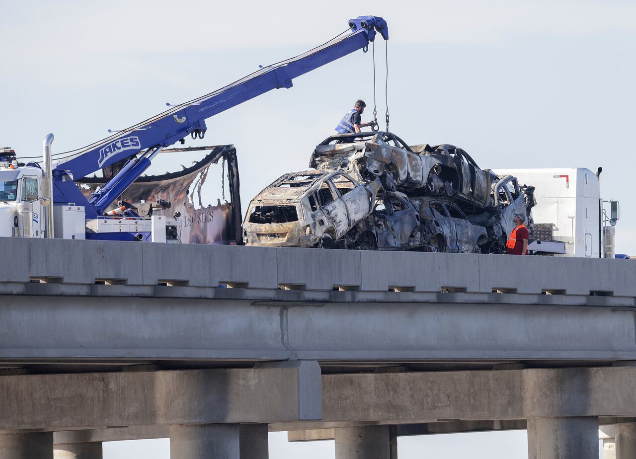 Trabajadores retiran varios vehículos quemados de la carretera interestatal 55 el lunes 23 de octubre de 2023, cerca de Manchac, Luisiana, luego de un choque múltiple. (Brett Duke/The Times-Picayune/The New Orleans Advocate vía AP)