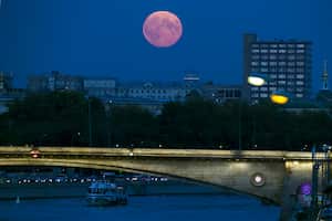 Una luna roja se asoma sobre el río Moscú en Rusia. Cuando la luna, durante mediados de octubre, se ve como roja a naranja, se le conoce como ‘luna de sangre’ o ‘luna de la cosecha’. (AP)