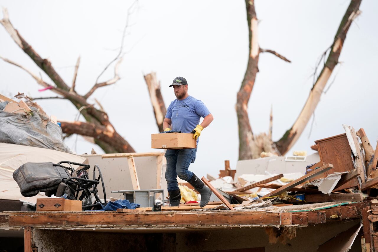 Un hombre busca entre los restos de una casa dañada por un tornado el martes 21 de mayo de 2024 en Greenfield, Iowa.