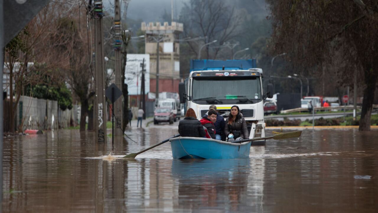 TALCA, CHILE - AUGUST 22: People pass the flooded street with a boat in Talca, Chile on August 22, 2023. Rivers overflowed, and roads damaged, while thousands of Chileans remain isolated or homeless due to torrential rains that have been recorded since last Saturday in the center and south of the country. The National Disaster Prevention and Response Service reported that, in addition to the two deceased, 30,000 people were isolated and 33,895 people were evacuated. (Photo by Lucas Aguayo Araos/Anadolu Agency via Getty Images)