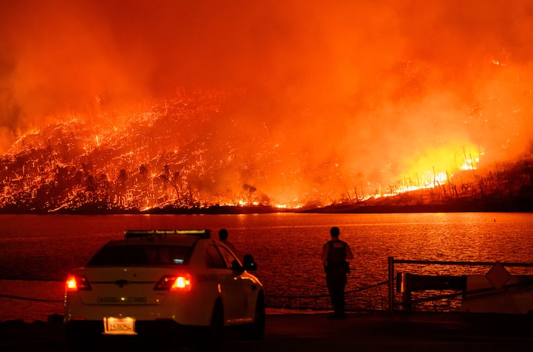 Los miembros de las fuerzas del orden observan cómo el incendio Thompson arde sobre el lago Oroville en Oroville, California, el 2 de julio de 2024.