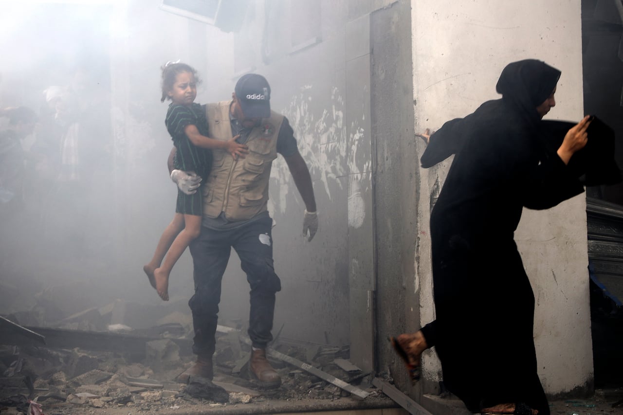 Miembros de una familia palestina salen corriendo de una casa bombardeada durante los ataques aéreos israelíes en la ciudad de Gaza el 9 de octubre de 2023.