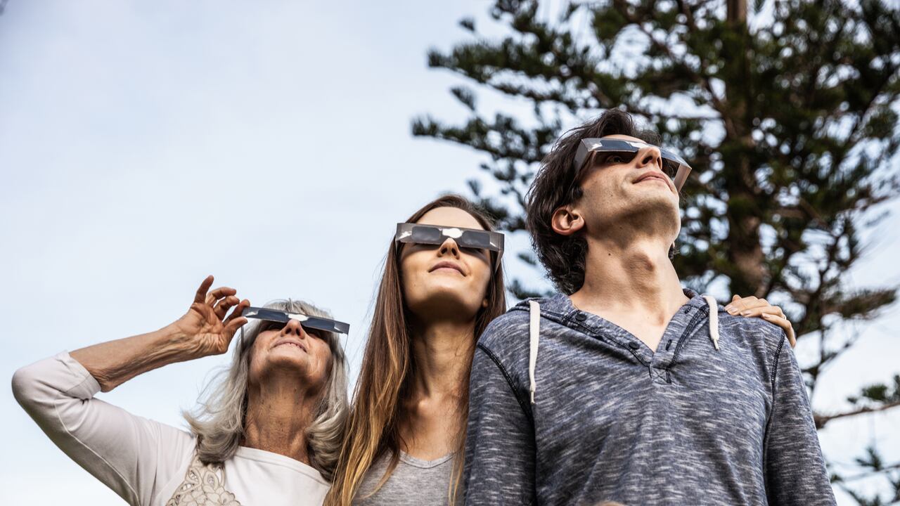 Familia viendo un eclipse con protección en los ojos