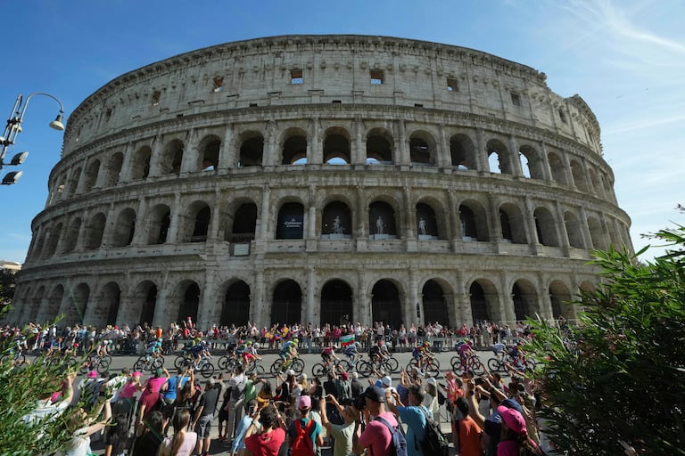 Los ciclistas son aclamados por los fanáticos mientras pasan por el antiguo Coliseo durante la etapa final de la carrera ciclista Giro de Italia en Roma, el domingo 26 de mayo de 2024. (Gian Mattia D'Alberto/LaPresse vía AP)