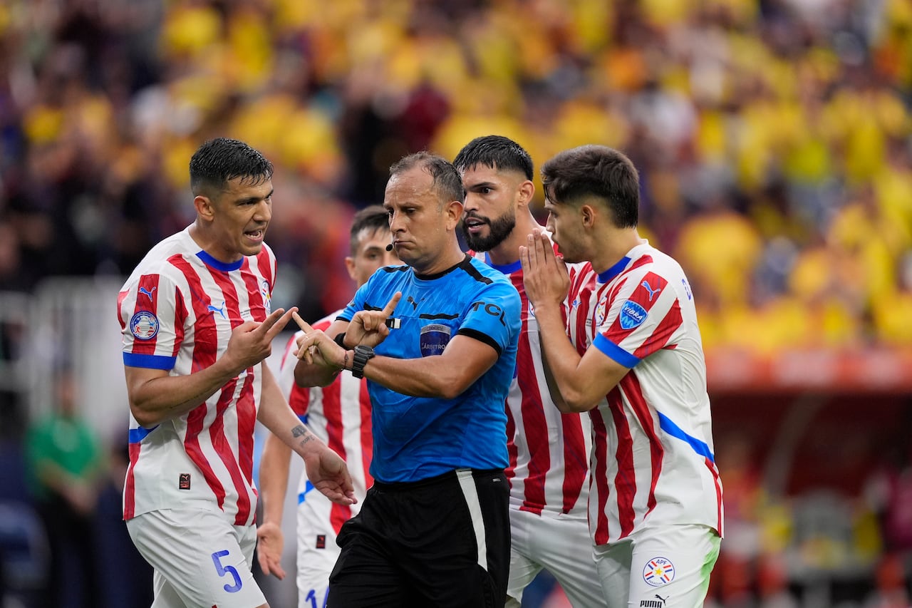 Paraguay's players argue with referee Dario Herrera of Argentina during a Copa America Group D soccer match against Colombia in Houston, Monday, June 24, 2024. (AP Photo/David J. Phillip)