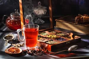 Té rojo con una caja de té de hierbas y especias aromáticas con tetera de vidrio y taza de té
