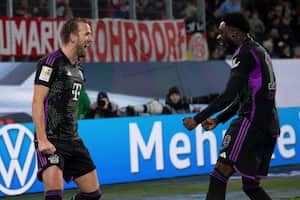 Bayern's Harry Kane, left, celebrates with teammate Alphonso Davies after scoring his side's second goal of the game during the German Bundesliga soccer match between VfL Wolfsburg and Bayern Munich at the Volkswagen Arena, Wolfsburg, Germany, Wednesday, Dec. 20, 2023. (Swen Pfortner/dpa via AP)