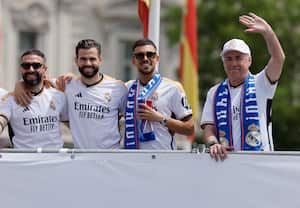 Real Madrid's Italian coach Carlo Ancelotti waves next to Real Madrid players as they parade onboard a bus to celebrate their 36th La Liga trophy at the Cibeles square in Madrid on May 12, 2024. Real Madrid's fans line the streets of Madrid as 'Los blancos' celebrate their 36th Liga trophy before facing Borussia Dortmund at Wembley in the Champions League final on June 1. (Photo by OSCAR DEL POZO / AFP)