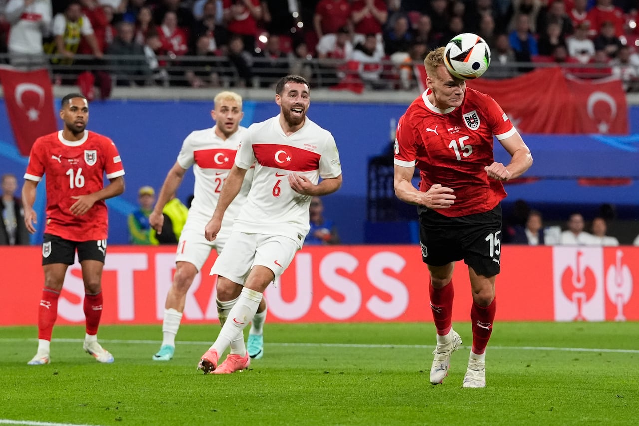 Philipp Lienhart, de Austria, a la derecha, cabecea el balón durante un partido de octavos de final entre Austria y Turquía en el torneo de fútbol Euro 2024 en Leipzig, Alemania, el martes 2 de julio de 2024. (Foto AP/Martin Meissner)